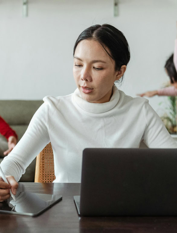 Woman on computer with kids in background